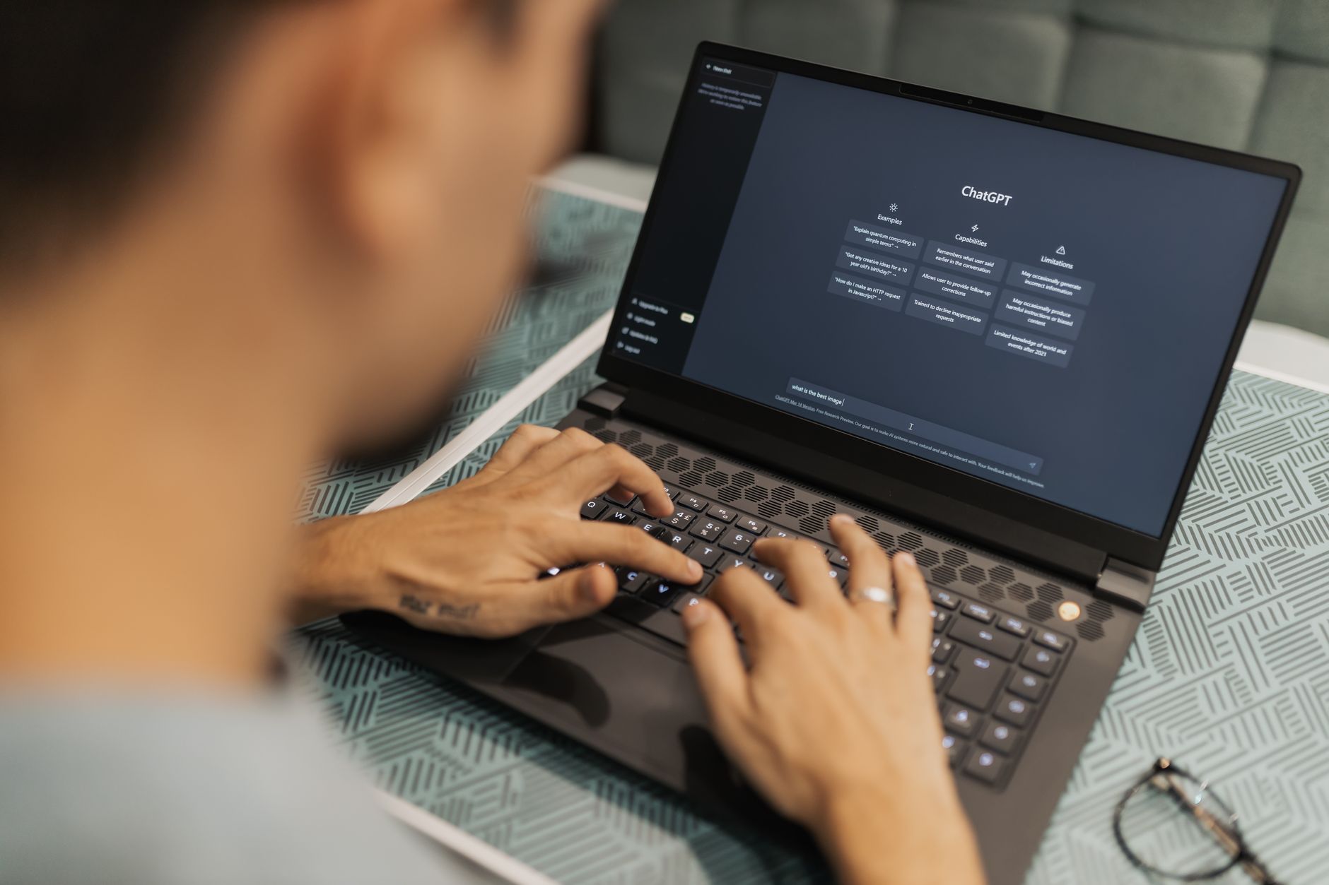 person typing on a laptop with an AI writing tool dashboard open